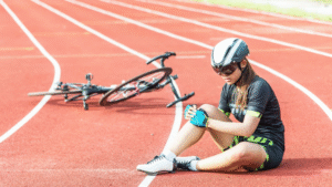 A cyclist sits on a track after a knee injury. PRP therapy is increasingly used to treat sports-related knee injuries such as this, aiming to accelerate healing and reduce pain. The minimally invasive nature of PRP – using the patient’s own blood components – makes it an attractive option for athletes seeking faster recovery.